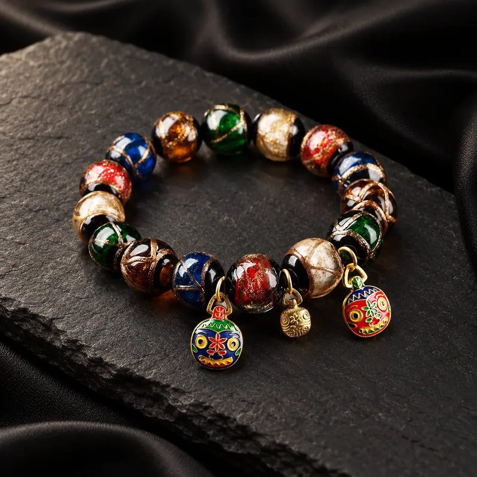 Hand-finished bracelet with symbolic charms on dark mineral stone