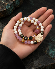 Ninefold Grace double-wrap bracelet in an open palm